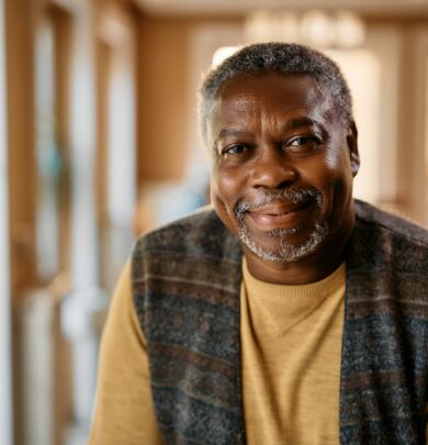 Happy African American senior at nursing home looking at camera.