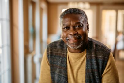 Happy African American senior at nursing home looking at camera.